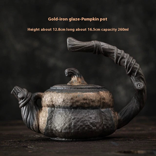 Coarse pottery teapot with gilded handle